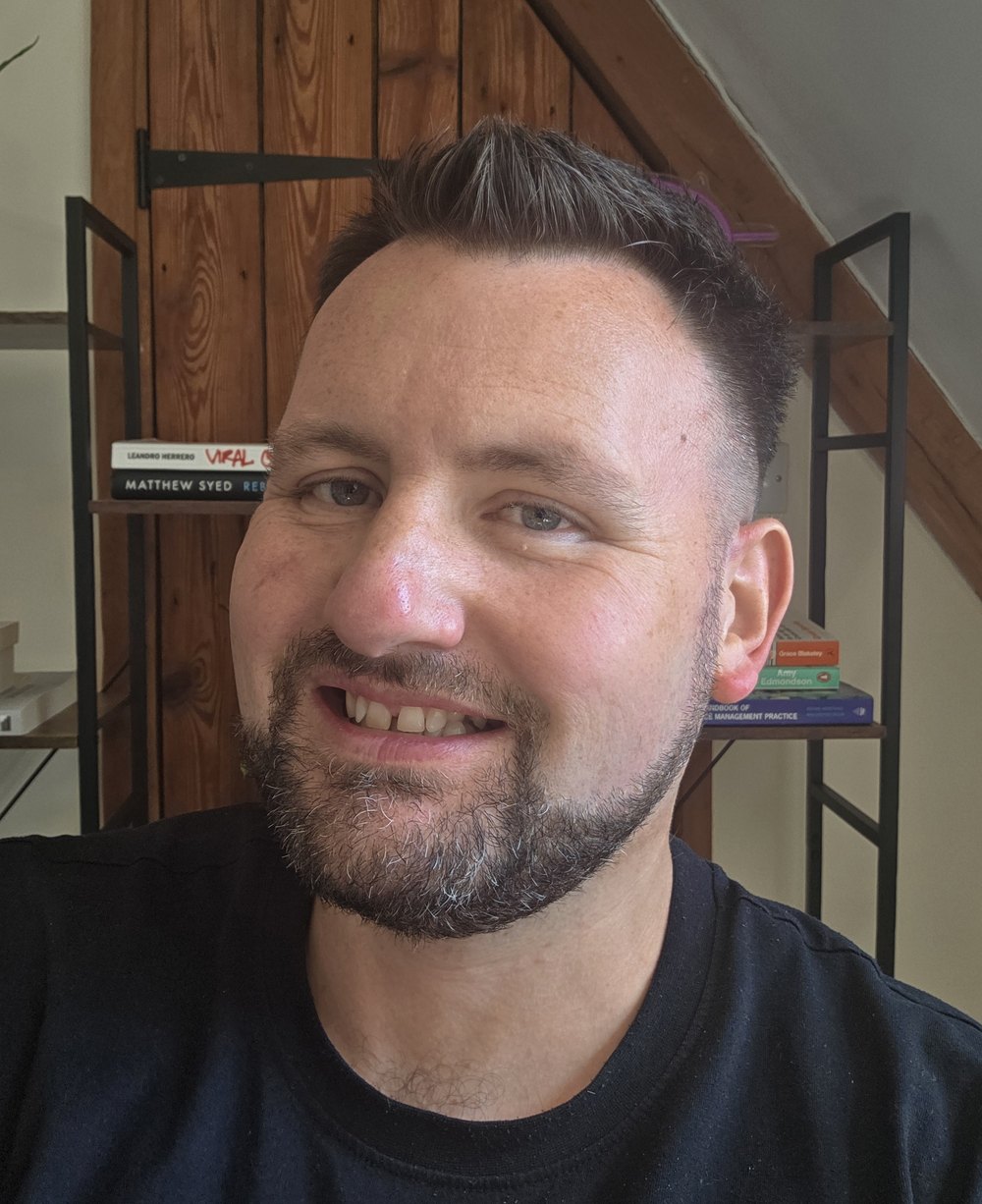 Terry McCall smiling in front of a bookshelf